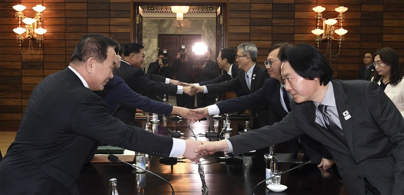 The Associated Press KOREAN OFFICIALS: In this photo provided by South Korea Unification Ministry, South Korean delegation, right, shakes hands with North Korean delegation, left, for their meeting at the North side of Panmunjom on Monday in North Korea. Officials from the Koreas met Monday to work out details about North Korea's plan to send an art troupe to the South during next month's Winter Olympics, as the rivals tried to follow up on the North's recent agreement to cooperate in the Games in a conciliatory gesture following months of nuclear tensions.