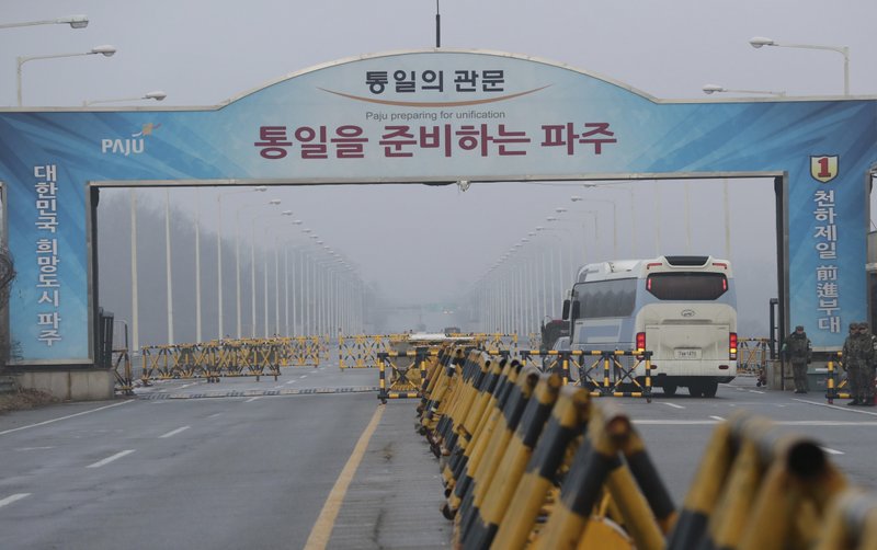 A bus carrying the South Korean delegations passes as South Korean soldier salutes at Unification Bridge, which leads to the Panmunjom in the Demilitarized Zone in Paju, South Korea, Monday, Jan. 15, 2018. The rival Koreas agreed to discuss a North Korean art troupe's visit to the Pyeongchang Winter Olympics in the South. 