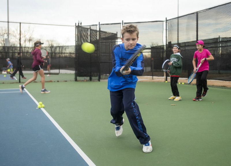Konner King, 11, of Springdale takes part in a drill Jan. 10 during practice with the Bentonville Parks and Recreation junior tennis program at Memorial Park in Bentonville.
