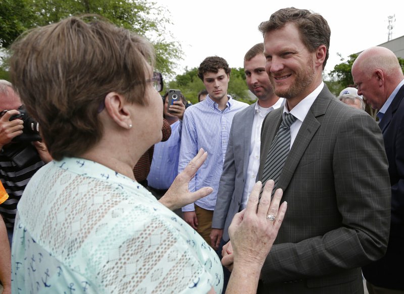 AP File Photo/Chuck Burton - In this April 25, 2017, file photo, Dale Earnhardt Jr., right, talks with a fan after a news conference at Hendrick Motorsports in Concord, N.C. Earnhardt Jr. barely had time to ease into retirement before NBC Sports gave him a full workload. Earnhardt will be part of the network's pregame show before the Super Bowl, then head to South Korea for NBC Sports' coverage of next month's Olympics.