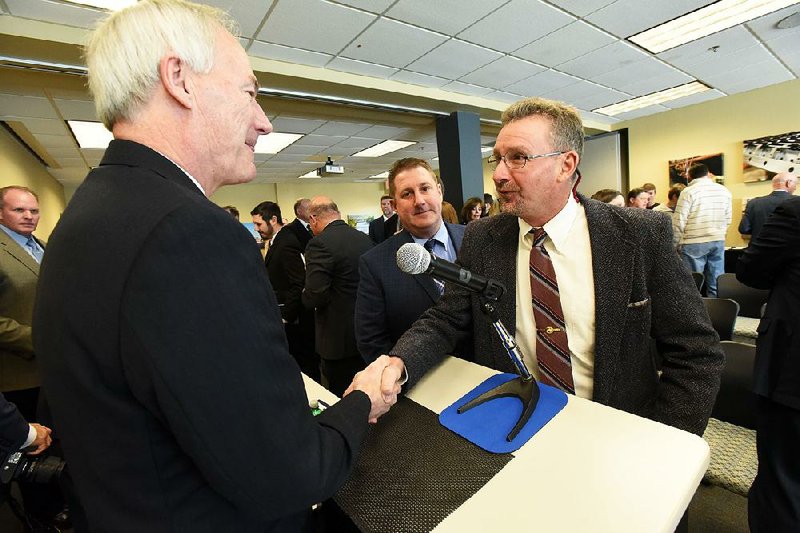 Turkey farmer Jeff Lindsey (right) greets Gov. Asa Hutchinson during a conference on the North American Free Trade Agreement in Rogers. Lindsey said the uncertainty in U.S. trade negotiations with Mexico and Canada makes him worry about his family’s future. 