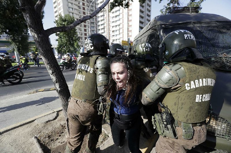 A protester of Pope Francis’ visit is arrested Tuesday in Santiago, Chile, where the Vatican’s handling of sexual abuse cases has provoked criticism. 
