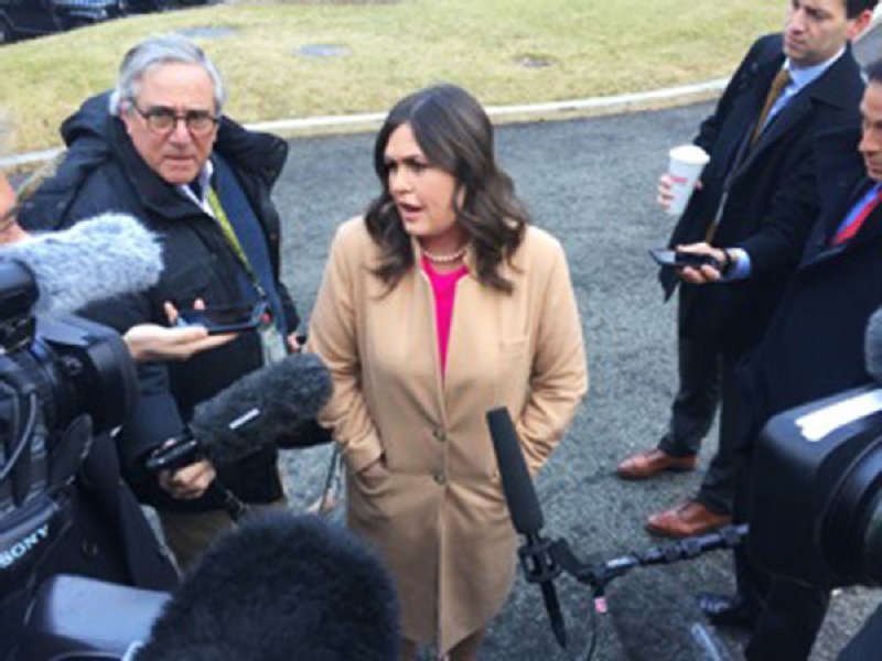 White House Press Secretary Sarah Huckabee Sanders blasts Democrats on Tuesday during an impromptu question-and-answer session with reporters in the White House driveway. The day’s press pool reporters, including one from the Democrat-Gazette, were able to witness the event. 