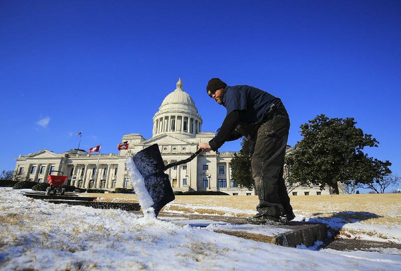 Kevin Brown of the grounds and maintenance department at the state Capitol works Tuesday morning clearing sidewalks in front of the Capitol in Little Rock. 
