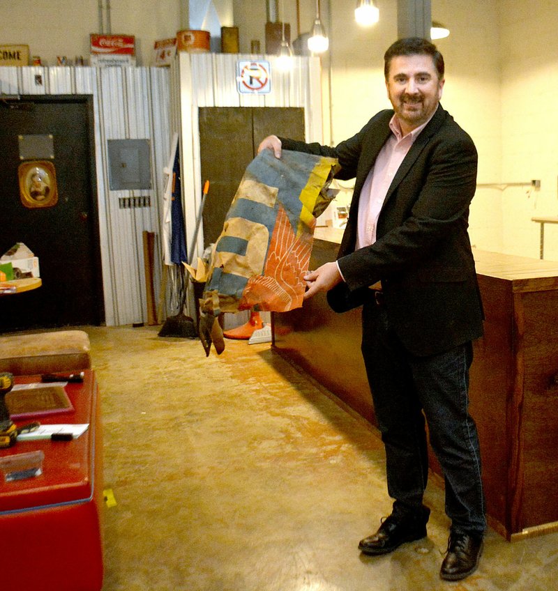 JANELLE JESSEN ENTERPRISE-LEADER Rick Ault displays the vintage Mobilgas banner he found in the crawl space inside the Prairie Grove Town Center. It was one of many treasures unearthed during the restoration of the building. Ault is standing in the Magnolia Coffee House portion of the town center, which was being renovated at the time. The coffee house has since been completed and os now open.