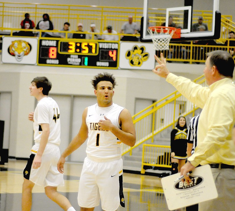 MARK HUMPHREY ENTERPRISE-LEADER Prairie Grove boys basketball coach Steve Edmiston (right) gives instructions to senior guard Anthony Johnson during a Nov. 27 rivalry game against Farmington. The Tigers beat 7A Rogers, then lost to a pair of Oklahoma teams during the Siloam Springs Holiday Classic basketball tournament Dec. 28-30.
