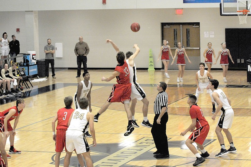 MARK HUMPHREY ENTERPRISE-LEADER Farmington senior Jacob Gray jumps center during the tip-off of the Cardinals' last game before Christmas, a 65-36 loss to 7A Bentonville West on Dec. 19. In their first game after New Year's Day, the Cardinals lost 64-59 at Siloam Springs on Jan. 3.