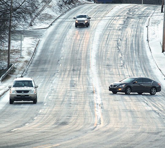 The Sentinel-Record/Richard Rasmussen ICY ROADS: Motorists head down the 1700 block of Malvern Avenue, which was slick with ice and snow, Tuesday morning. All seven public school districts in the county, along with county government offices, closed due to the inclement weather.