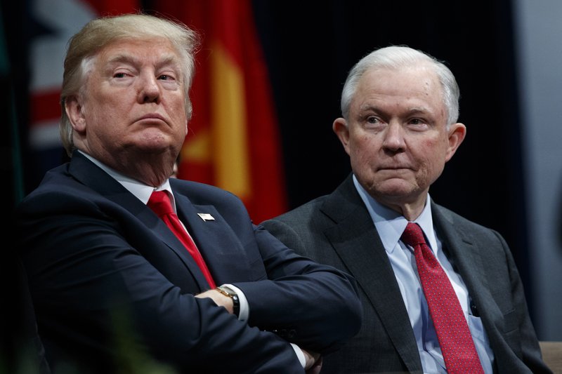 FILE - In this Dec. 15, 2017 file photo, President Donald Trump, left, sits with Attorney General Jeff Sessions during the FBI National Academy graduation ceremony in Quantico, Va. (AP Photo/Evan Vucci, File)