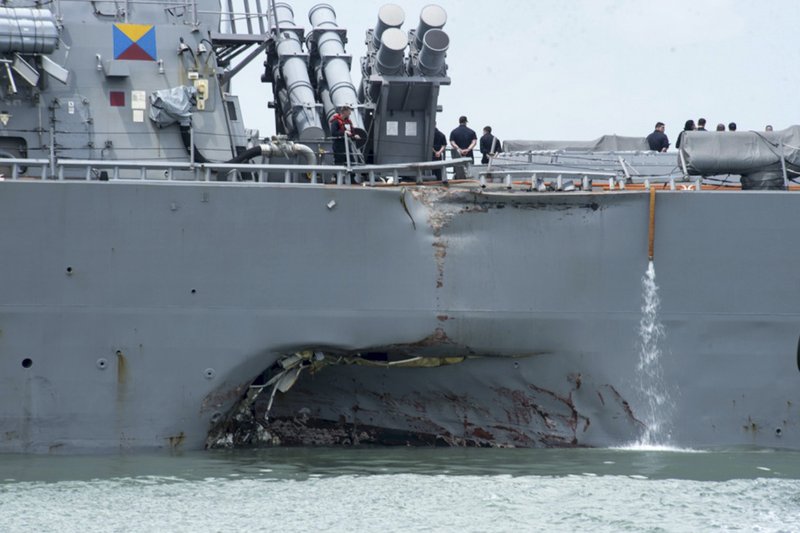 FILE - In this Aug. 21, 2017, file photo, provided by the U.S. Navy, damage is visible as the guided-missile destroyer USS John S. McCain steers towards Changi naval base in Singapore following a collision with the merchant vessel Alnic MC. The Navy says it is filing negligent homicide charges against the commanders of two ships involved in fatal collisions last year. The charges are to be presented at what the military calls an Article 32 hearing, which will determine whether the accused are court martialed. (Mass Communication Specialist 2nd Class Joshua Fulton/U.S. Navy photo via AP, File)