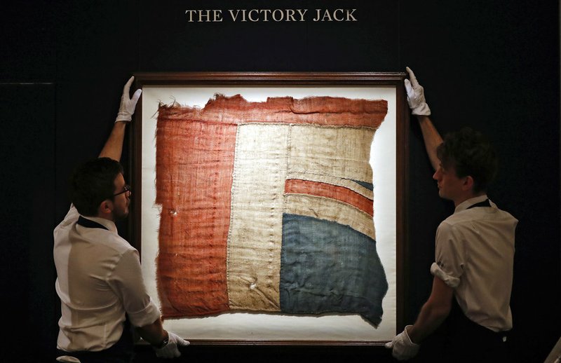 AP File Photo/Frank Augstein In this Thursday, Jan. 11, 2018 file photo, Sotheby's employees adjust a frame with a fragment of the Union Flag, which flew from HMS Victory at the Battle of Trafalgar, in London. Sotheby's auction house on Wednesday, Jan. 18, said a fragment of the red, white and blue "Victory Jack" flag that flew from Adm. Horatio Nelson's flagship during the Battle of Trafalgar has sold for 297,000 pounds ($408,761).