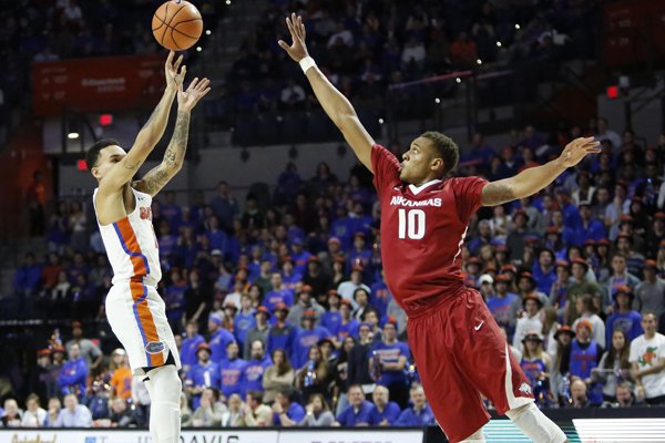 Florida guard Chris Chiozza (11) goes up for a 3-point shot against an Arkansas defender during an NCAA college basketball game in Gainesville, Fla., Wednesday Jan. 17, 2018. Florida won, 88-73. (Brad McClenny/The Gainesville Sun via AP)

