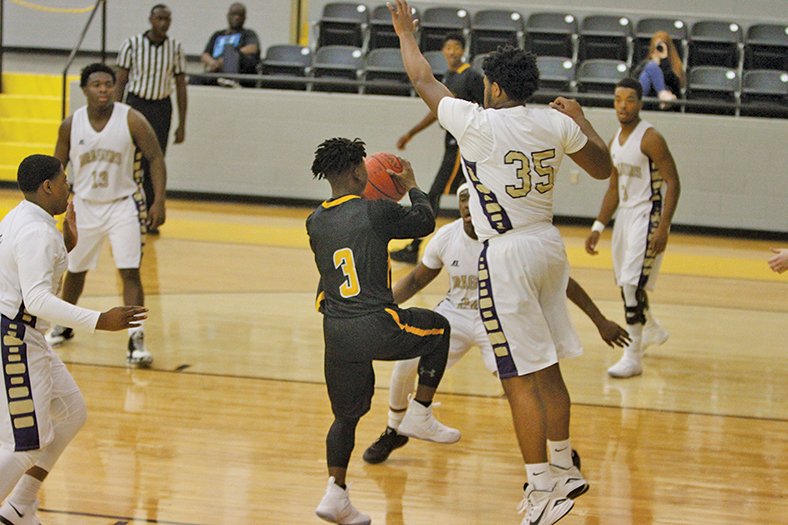 Terrance Armstard/News-Times Junction City's Charles Hoof (35) and Hishmma Taylor (24) guard Harmony Grove's Xaylon Falls (3) during their contest at the Hampton Holiday Classic earlier this season. Junction City hosts Warren tonight.