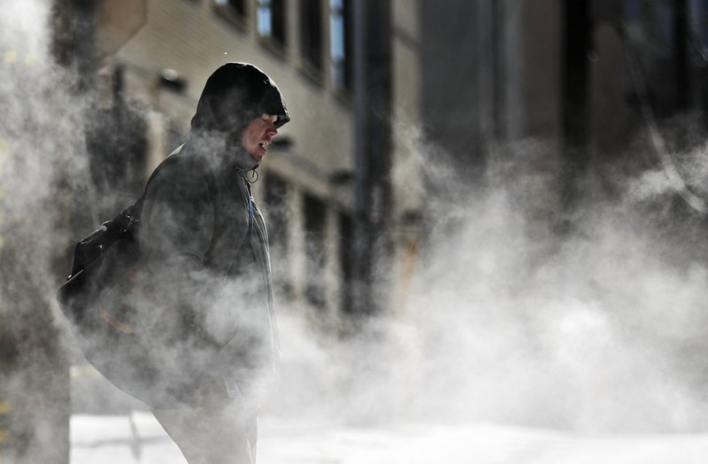 A man walks through steam venting from a building in the cold weather in Atlanta, Wednesday, Jan. 17, 2018. The South awoke on Wednesday to a two-part Arctic mess. First came a thin blanket of snow and ice, and then came the below-zero wind chills and record-breaking low temperatures in New Orleans and other cities. (AP Photo/David Goldman)
