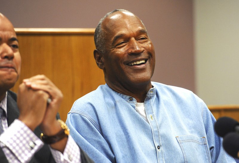 FILE - In this July 20, 2017, file photo, former NFL football star O.J. Simpson laughs as he appears via video for his parole hearing at the Lovelock Correctional Center in Lovelock, Nev. Simpson enjoys living in Las Vegas, and isn't planning to move to Florida like he told state parole officials before he was released in October from Nevada state prison. (Jason Bean/The Reno Gazette-Journal via AP, Pool, File)