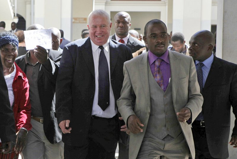 AP File Photo/Tsvangirayi Mukwazhi - In this May, 10, 2010, file photo, Roy Bennett, center left, leaves the High Court in Harare, Zimbabwe, after he was acquitted of terrorism charges. New Mexico State Police said Thursday, Jan. 18 2018, that Zimbabwean opposition leader Roy Bennett died in helicopter crash. The crash on Wednesday, Jan. 17, carrying Bennett and five others went down in a mountainous rural area of northern New Mexico.