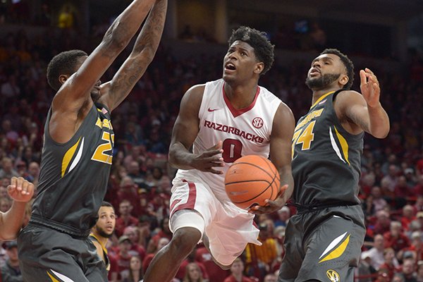 Arkansas guard Jaylen Barford (0) drives to the basket as he is pressured by Missouri forward Jeremiah Tilmon (left) Saturday, Jan. 13, 2018, during the second half in Bud Walton Arena. 