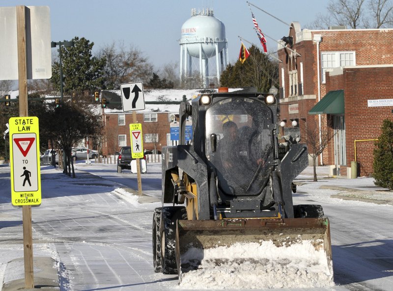 City of New Bern Public Works staff clear streets of ice and snow in downtown New Bern, N.C., Thursday, Jan. 18, 2018, after a brief winter front brought frigid weather across the region overnight. (Gray Whitley /Sun Journal via AP)