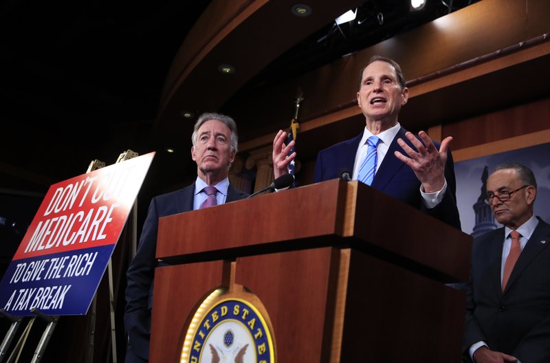 In this Oct. 4, 2017 photo, Rep. Ron Wyden, D-Ore. with Rep. Richard Neal, D-Mass., left, and Senate Minority Leader Chuck Schumer of New York, right, speak during a news conference on Capitol Hill in Washington, Wednesday, Oct. 4, 2017, urging Republicans to abandon cuts to Medicare and Medicaid. More than two dozen Senate Democrats are questioning the legality of the Trump administration's new policy that allows states to require low-income adults to work in order to get Medicaid coverage. In a letter to the administration, the lawmakers say work requirements are out of line with the plain meaning of the Medicaid law, as well as with congressional intent. Expect opponents of the plan to make that argument in a lawsuit. (AP Photo/Manuel Balce Ceneta)
