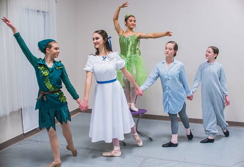 Tinker Bell, back, portrayed by Abby Woods, watches as Peter Pan, from left, played by Rebecca Dillon, leads the Darling children — Wendy, portrayed by Maria Casavechia; John, played by Riley Cecil; and Michael, portrayed by Mary Caroline Grimes — to Neverland. The familiar characters will take the stage Saturday as Blackbird Academy presents Peter Pan the Ballet at the Donald W. Reynolds Performance Hall at the University of Central Arkansas in Conway.