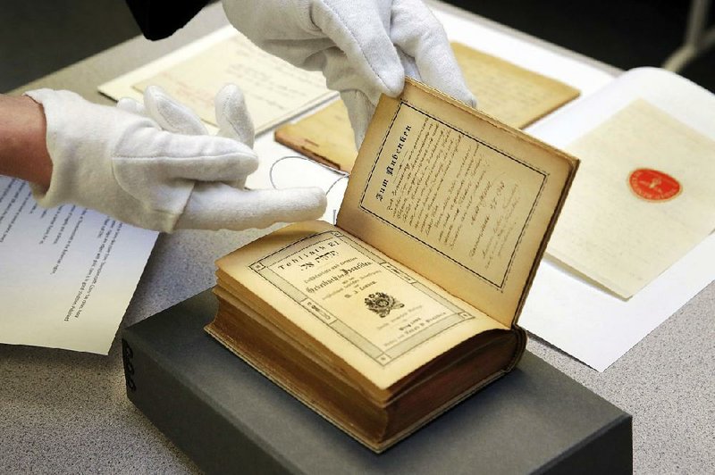 Dovid Reidel, director of the Amud Aish Memorial Museum’s research and archive division, displays an 1893 prayer book, part of the museum’s collection, that was found by a U.S. soldier in the Theresienstadt concentration camp in Czechoslovakia during World War II.