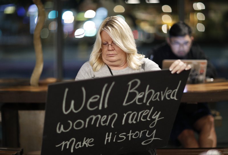 In this Jan. 17, 2018, photo, Jeri Burton makes a sign in preparation for a rally in Las Vegas. A year after more than 1 million people rallied at women's marches around the world with a message of female empowerment and protest of President Donald Trump, organizers will mark the anniversary with more than a hundred marches around the world and a rally in Las Vegas aiming to channel the activism to register voters and swing elections for progressives this year. (AP Photo/John Locher)