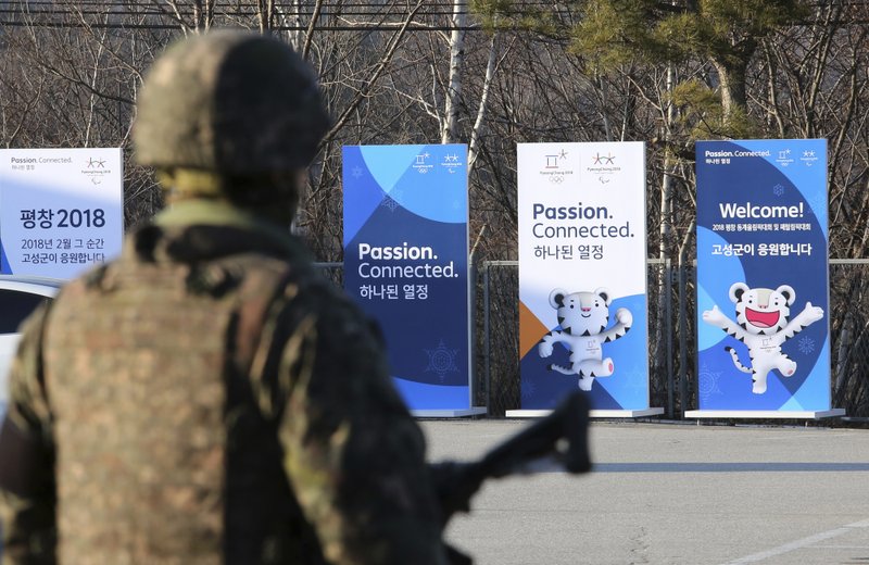 Posters showing the 2018 Pyeongchang Winter Olympic mascot are displayed as a South Korean army soldier stands guard at the Unification Observation post in Goseong, near the border with North Korea, South Korea, Friday, Jan. 19, 2018. The rival Koreas agreed Wednesday to form their first unified Olympic team and have their athletes parade together for the first time in 11 years during the opening ceremony of next month's Winter Olympics in South Korea, officials said. 