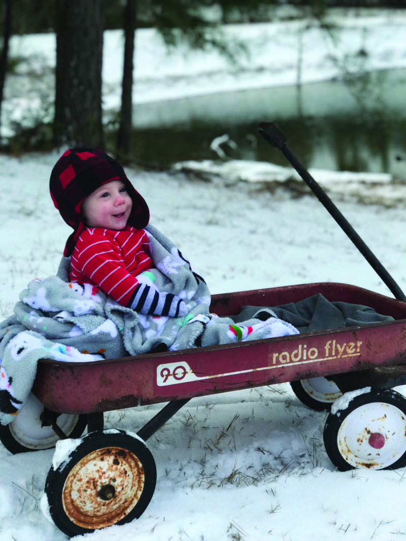 Radio flyer: Seven-month-old Luke Caldwell (left) enjoys his first snow in Lawson, Photo submitted by Callie Caldwell. 