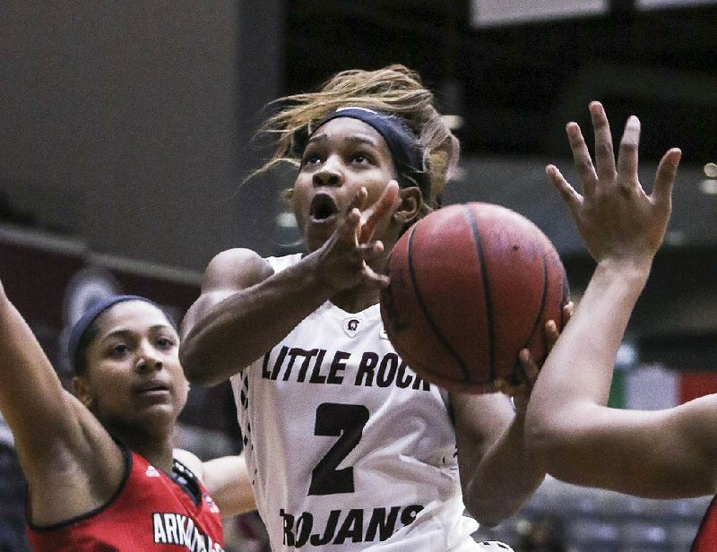 UALR’s Monique Townson drives between Arkansas State defenders during the Trojans’ victory Saturday at the Jack Stephens Center in Little Rock.