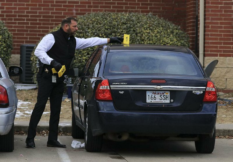 A Pulaski County sheriff’s official gathers evidence on Jan. 19, 2018, after a fatal shooting at Fairfax Crossing Apartments. It was the second homicide at the complex in less than four months.