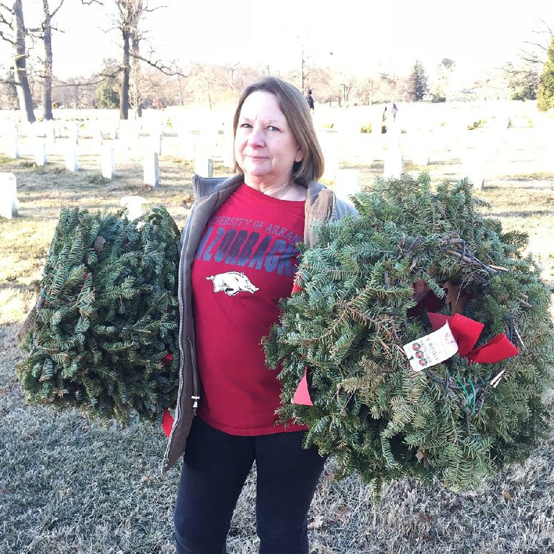 Pamela Buckingham of Ashdown picks up wreaths Saturday at Arlington National Cemetery in Virginia.