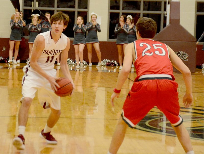 Graham Thomas/Siloam Sunday Siloam Springs senior Sam Everett looks to pass as Russellville's Rhett Adkins defends on the play during Tuesday's game at Panther Activity Center.