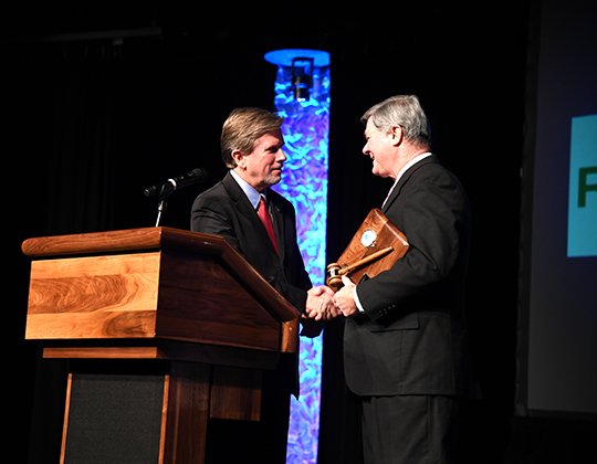 The Sentinel-Record/Grace Brown - The Greater Hot Springs Chamber of Commerce outgoing chairman of the board Latt Bachelor, right, ceremoniously passes the gavel to incoming chairman Mark Curry, during the the chamber's 2018 Annual Banquet &amp; 2017 Community Service Awards at the Hot Springs Convention Center on Thursday, Jan. 18, 2018.