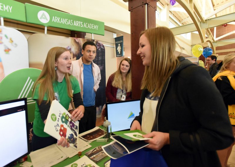 Rachel Carpenter (left), a music teacher at Arkansas Arts Academy in Rogers, shares information Saturday about the school at the annual Northwest Arkansas School Choice Festival. Representatives from dozens of public and private schools offered information about the varied education opportunities in Northwest Arkansas at the event held at The Jones Center in Springdale. The group, NWA School Choice, put on the event. Music, crafts and prize drawings were part of the festivities.