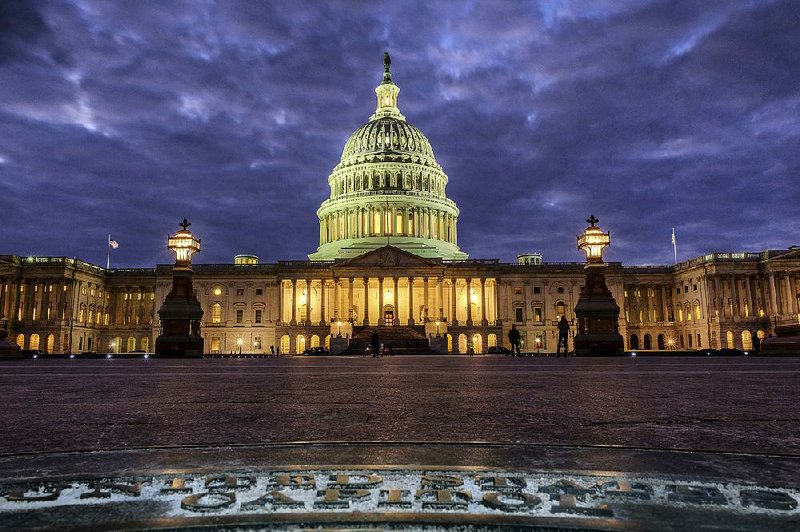 Lights shine inside the U.S. Capitol as night falls Sunday in Washington and as Congress continues to negotiate during the second day of the federal government shutdown.