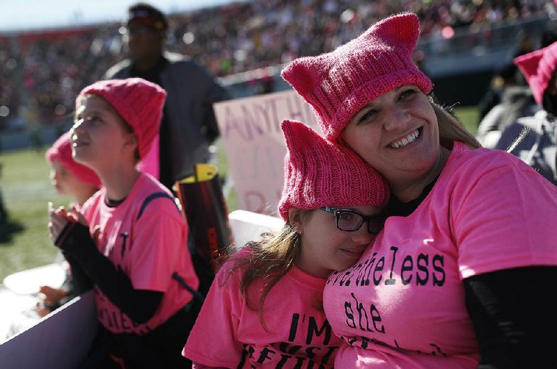 Eight-year-old Zoe Rodis leans on her mother, Jennifer Rodis, during a Women’s March rally Sunday in Las Vegas.
