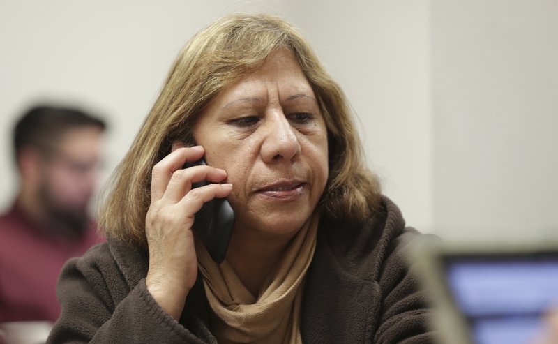 In this Dec. 27, 2017, photo, legal U.S. resident Maria Ana Pina listens to a Spanish language help line while she signs up for the Affordable Care Act at the Community Council offices in Dallas. Since President Donald Trump took office a year ago, the number of Latino immigrants accessing public health services and enrolling in federally subsidized insurance plans has dipped substantially, according to health advocates across the country. (AP Photo/LM Otero)