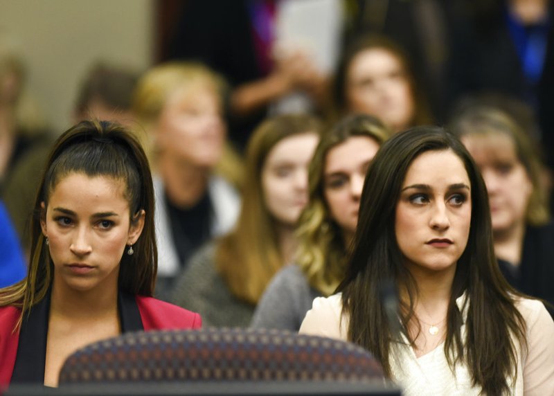 Lansing State Journal via AP)/Matthew Dae Smith Former Olympians Aly Raisman, left, and Jordyn Wieber sit in Circuit Judge Rosemarie Aquilina's courtroom during the fourth day of sentencing for former sports doctor Larry Nassar, who pled guilty to multiple counts of sexual assault, Friday, Jan. 19, 2018, in Lansing, Mich.