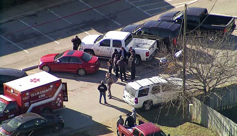 This photo from video by KDFW Fox4 shows law enforcement personnel gathered outside a high school in Italy, Texas, after an active shooter incident at the school Monday morning, Jan. 22, 2018. 