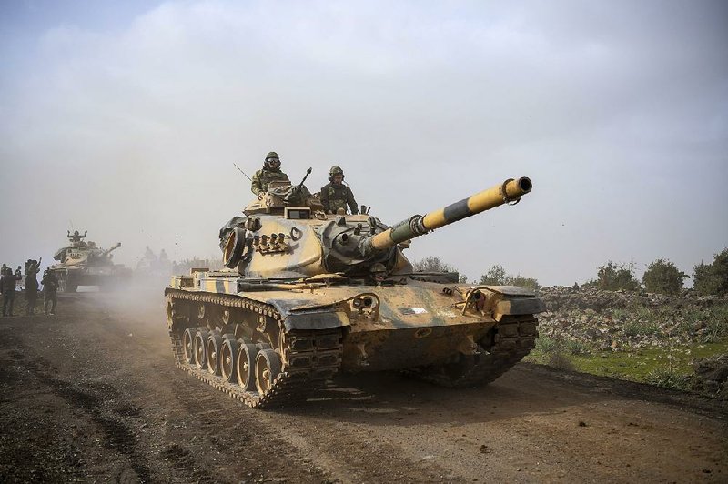 Turkish army tanks on Monday enter Afrin, an enclave in northern Syria controlled by U.S.-allied Kurdish fighters, from Hassa, Turkey.