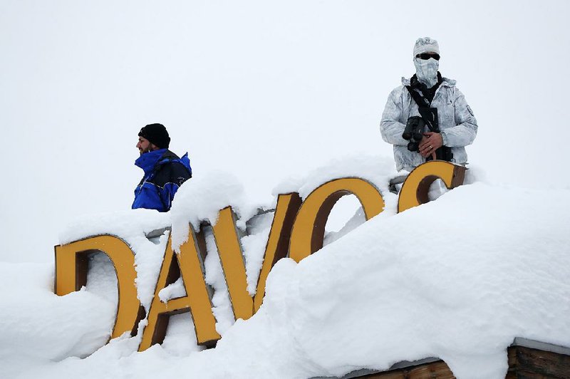 An armed member of the Swiss police watches from the roof of the Hotel Davos ahead of the World Economic Forum in Davos, Switzerland, on Monday. World leaders, executives, bankers and policymakers will attend the 48th annual forum through Friday.