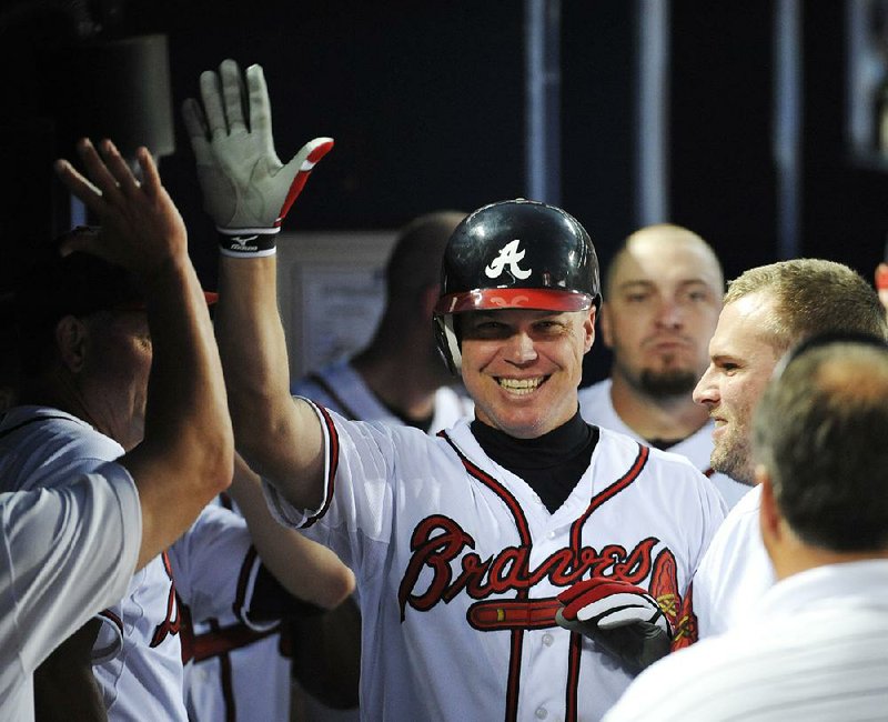 In this Aug. 16, 2012, file photo, Atlanta Braves' Chipper Jones celebrates with teammates after scoring a home run on his 2700th career hit in the fifth inning of a baseball game against the San Diego Padres, in Atlanta. All signs point to Jones being selected to the Baseball Hall of Fame when the next group of inductees is announced Wednesday, Jan. 24, 2018. 