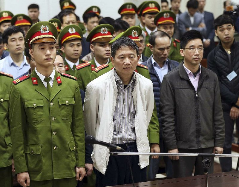 Trinh Xuan Thanh (center) stands in court in Hanoi, Vietnam, on Monday before the former oil executive was sentenced to life in prison on charges of embezzlement and mismanagement.