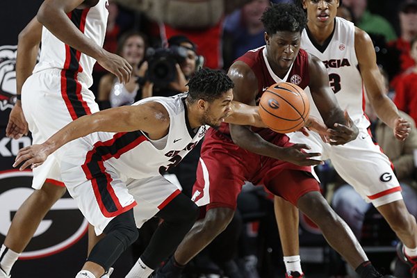 Georgia guard Juwan Parker (3) knocks the ball out of the hands of Arkansas guard Jaylen Barford (0) in overtime of an NCAA college basketball game in Athens, Ga., Tuesday, Jan. 23, 2018. (Joshua L. Jones/Athens Banner-Herald via AP)

