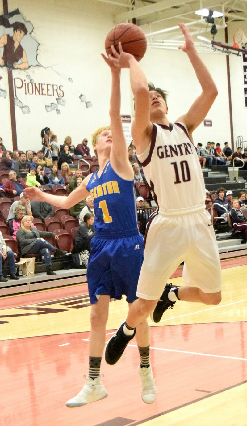 Westside Eagle Observer/MIKE ECKELS As Zach Jarnagan (Gentry 10) goes up for a layup, Bryson Funk (Decatur 1) gets a hand on the back of the ball during the first quarter of the Gentry-Decatur junior high boys' basketball contest Jan. 18 at Pioneer Gym in Gentry. Funk's block resulted in Jarnagan missing his shot.