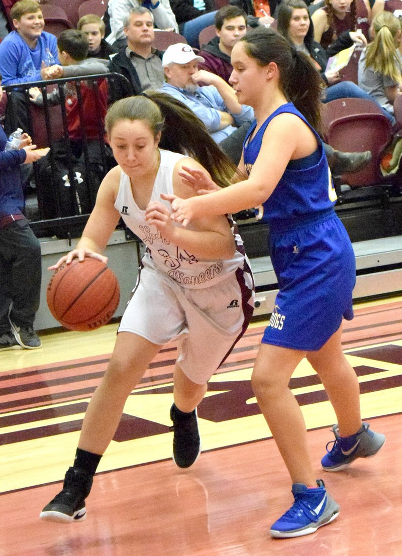 Westside Eagle Observer/MIKE ECKELS With Decatur's Jacey Smith (right) putting up a block, Cameron Thorburn (Gentry 34) drives towards the the lane during the Gentry-Decatur junior high girls' basketball contest at Pioneer Gym in Gentry Jan. 18.