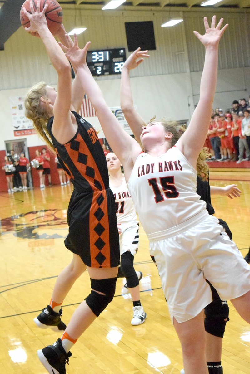 Westside Eagle Observer/MIKE ECKELS Jessica Bookout (Lady Lions 23) grabs a rebound away from Maria Socha (Lady Hawks 15) during the second quarter of the Pea Ridge-Gravette senior girls basketball contest at Blackhawk Gym in Pea Ridge Jan.19. The Lady Lions defeated the Lady Hawks 58-56.