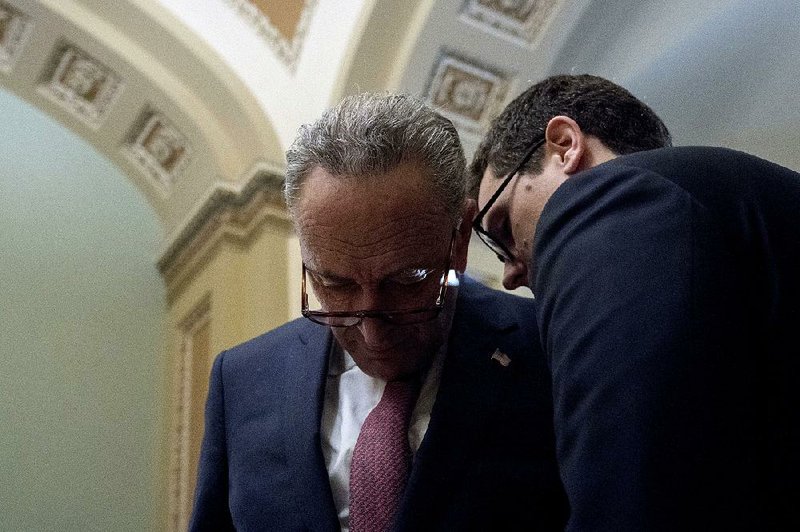 Senate Minority Leader Charles Schumer (left) confers with an aide Tuesday on Capitol Hill. “We’re going to have to start on a new basis,” Schumer said. 