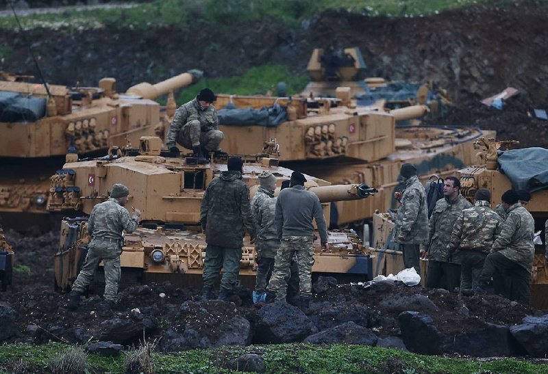 Turkish soldiers prepare their tanks to join an offensive against Kurdish fighters in northern Syria on Tuesday. Turkish troops and allied Syrian forces pressed operations against the U.S.-allied People’s Defense Units for a fourth day but were encountering fierce resistance. 
