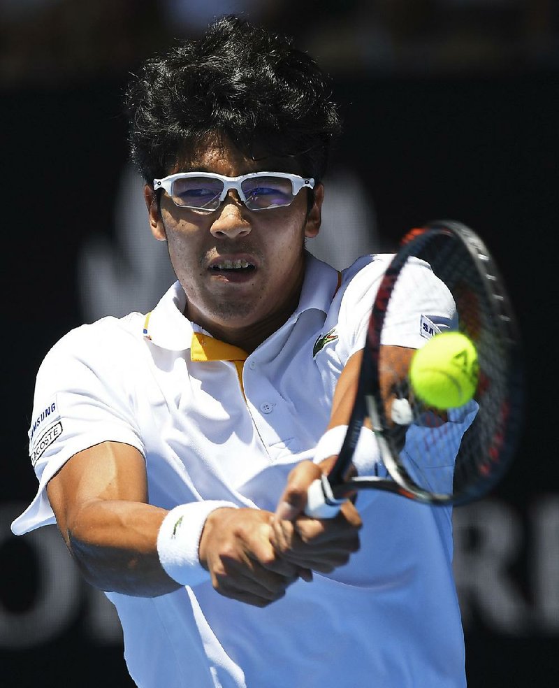 South Korea's Chung Hyeon makes a backhand return to United States' Tennys Sandgren during their quarterfinal at the Australian Open tennis championships in Melbourne, Australia, Wednesday, Jan. 24, 2018. 